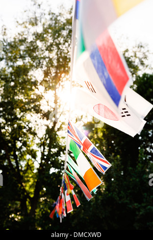 Banderas multinacionales en una cadena en una fiesta en el jardín. Foto de stock