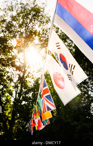 Banderas multinacionales en una cadena en una fiesta en el jardín. Foto de stock