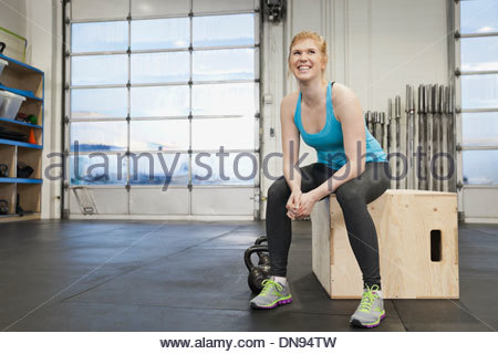 Mujer sentada en la caja en el gimnasio