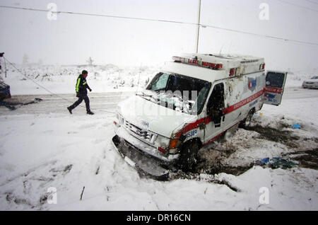 Dec 17, 2008 - Adelanto, California, EE.UU. - Un supervisor AMR toma fotografías como un conductor de camión de remolque trabaja en una ambulancia que arrastraban en la nieve en el Mirage Creek Road, cerca de ovejas en el Mirage, California, nadie resultó herido, como el desierto alto experimentaron un día de nieve el miércoles, 17 de diciembre de 2008. (Crédito de la Imagen: © Eric Reed/ZUMA Press) Foto de stock