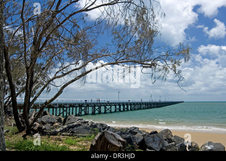 El paisaje costero en Hervey Bay, Queensland, Australia , con Urangan histórico muelle, playa y océano turquesa bajo un cielo azul Foto de stock