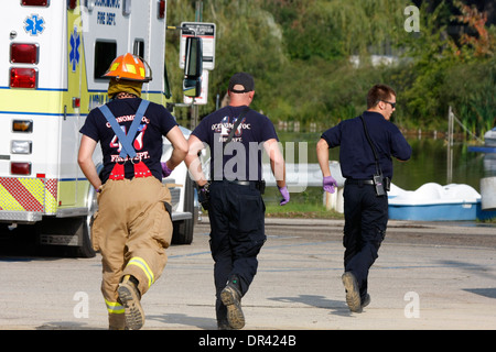 Tres técnicos sanitarios de bomberos corriendo para una emergencia Foto de stock