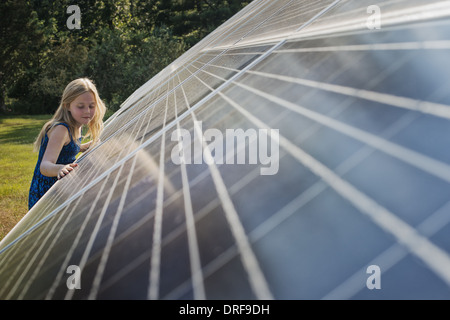 El estado de Nueva York, EE.UU. niña de pie junto a gran panel solar Foto de stock