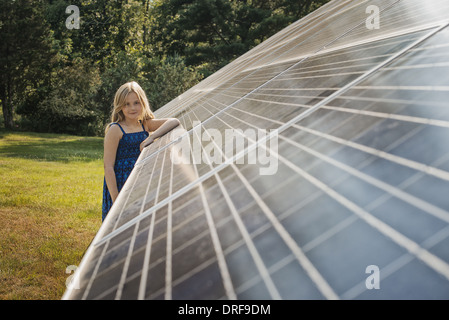 El estado de Nueva York, EE.UU. niña de pie junto a gran panel solar Foto de stock