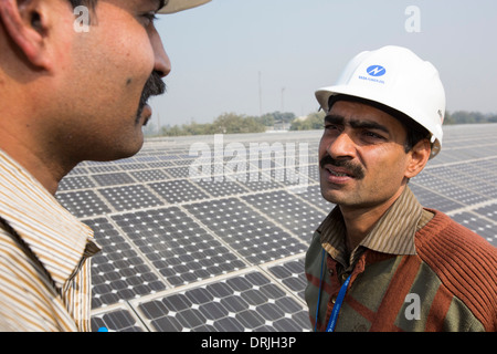 Los trabajadores de una estación de energía solar de 1 MW dirigidos por Tata power en el techo de una empresa eléctrica en Delhi, India. Foto de stock