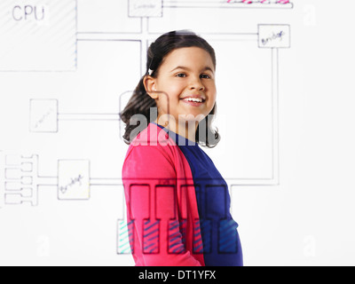Una niña mirando un dibujo de una placa base de PC ver dibujado en un circuito a través de la superficie transparente Foto de stock