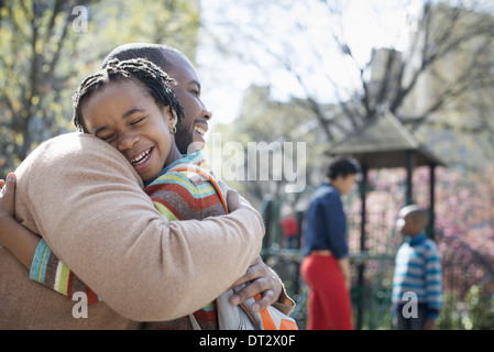 Una familia junto a un padre abrazando a su hijo