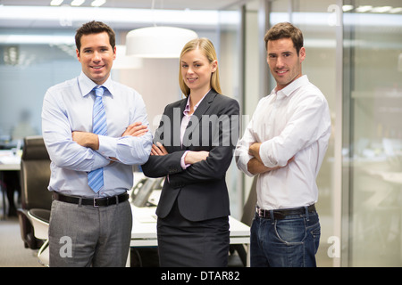 Retrato de sonriente equipo empresarial en oficina, mirando la cámara