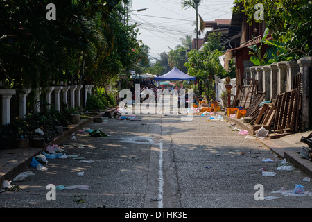 Basura en la calle como los vendedores cierran al final de la mañana el mercado en Luang Prabang, Laos.