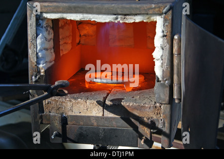 Herrero forja un hierro candente en la forja Fotografía de stock - Alamy