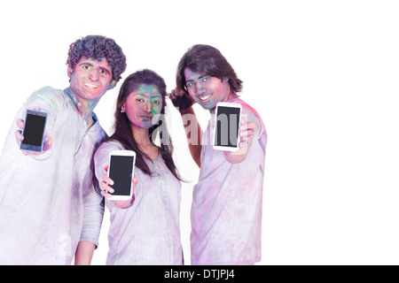 Amigos celebrar Holi y mostrando un teléfono móvil Foto de stock
