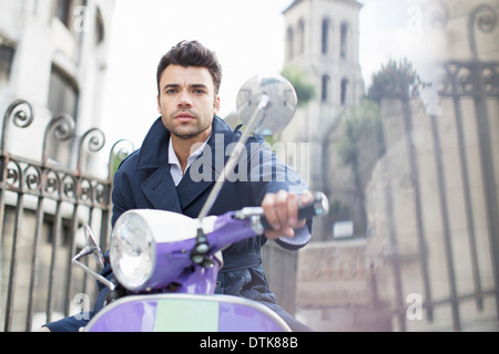 Hombre que conducía scooter en las calles de la ciudad