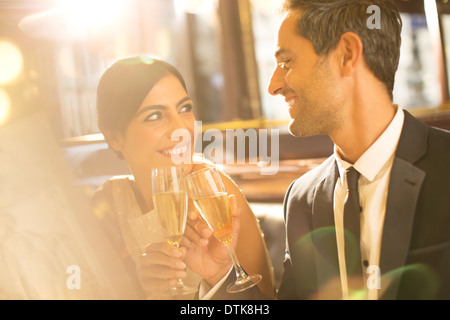 Bien vestida dos copas de champaña de tostado en restaurante. Foto de stock