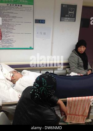 Kunming, la Provincia china de Yunnan. 2º de marzo de 2014. Una mujer herida en el ataque terrorista de Kunming recibe tratamiento en el primer hospital del pueblo de Kunming en Kunming, capital del suroeste de la Provincia china de Yunnan, 2 de marzo de 2014. Más de 10 presuntos terroristas atacaron a la gente en la plaza y venta de billetes de la estación de ferrocarril de Kunming a las 9:20 p.m. del sábado, matando al menos a 28 civiles e hiriendo a otros 113. La policía mató a tiros a cinco atacantes y la caza para el resto. © Li Meng/Xinhua/Alamy Live News Foto de stock