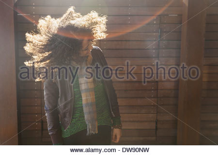 Mujer de pie afuera agitando su cabello