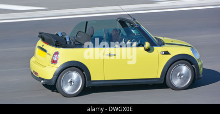 Dos puertas BMW Mini Cooper descapotable coche convertible con la mujer la conducción en autopista, Essex, Inglaterra