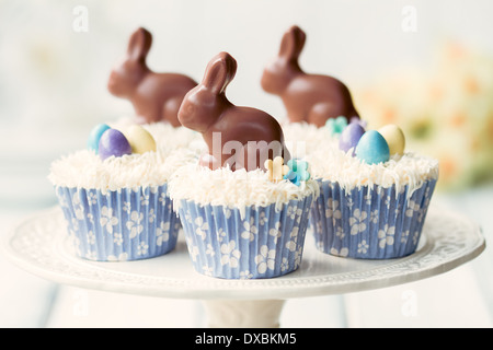 Las magdalenas decoradas con chocolate conejitos de Pascua Foto de stock