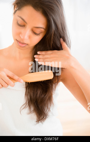 Cerca de la mujer asiática peinarse el pelo Foto de stock