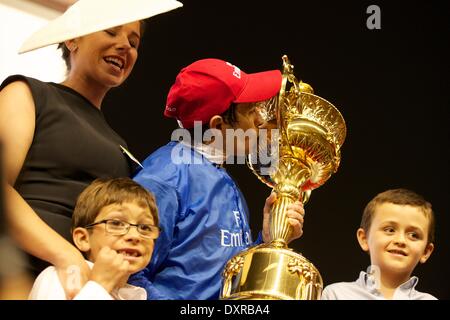 El hipódromo de Meydan, en Dubai, EAU. El 29 de marzo, 2014. Silvestre De Sousa besa la Copa del Mundo de Dubai como él está con su familia Credit: Tom Morgan/Alamy Live News Foto de stock