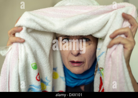 Mujer senior con un resfriado inhalando bajo una toalla, Alemania Foto de stock