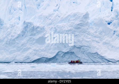 El turismo en la Antártida entre el paisaje de iceberg, glaciar, y hielo en zodiac con turistas. Península Antártica.