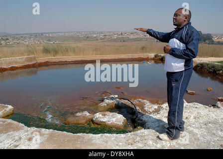 Sudáfrica, área de Witbank, 2 de septiembre de 2008: El veterano activista ambiental, Matthews Hlabane, explica cómo el agua fluye de AMD Foto de stock