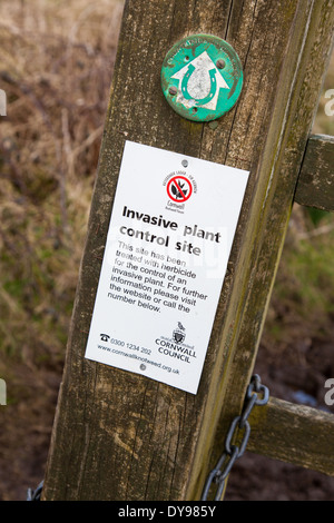 Un signo en un camino de herradura cartel diciendo que la zona ha sido tratada con herbicida para controlar una especie invasora de planta Foto de stock