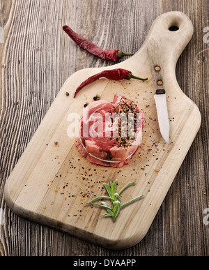 Trozo de carne cruda rojo bistec en la placa de corte Foto de stock