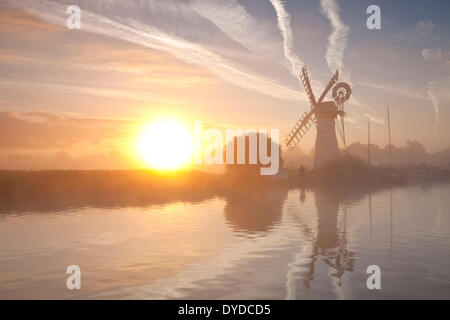 Thurne Mill al amanecer en una mañana de niebla en el Norfolk Broads. Foto de stock
