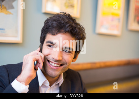 Sonriendo alegre restaurante smartphone macho