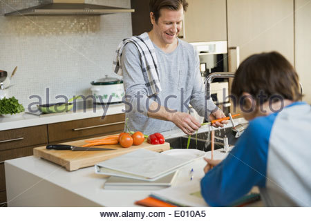 Padre e hijo de cocina haciendo los deberes en la cocina