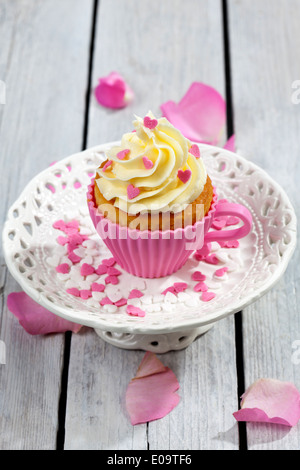 Hornear formado como copa con decorados cupcakes delante de rosas rosas  Fotografía de stock - Alamy