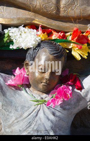 Primer plano detalle del Santuario de Nuestra Señora de Guadalupe estatua adornada con flores.