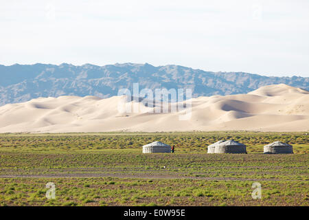Yurts o Gers, en la estepa verde delante de las grandes dunas de arena de Khongoryn Els, Gobi Gurvansaikhan Parque Nacional Foto de stock