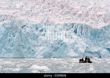 Los turistas a bordo de un bote de goma en la parte delantera de la llanta del Glaciar Monacobreen Liefdefjorden, Spitsbergen, Islas Svalbard