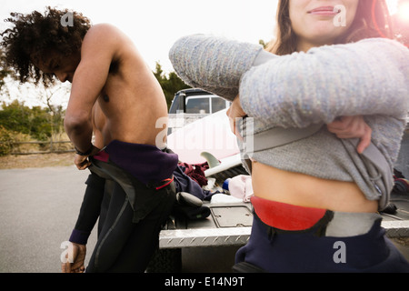 Los surfistas tirando de los trajes de neopreno por camión