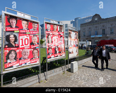 Dos hombres caminando pasado elecciones europeas carteles sobre la Place Luxembourg plaza, en el distrito de la UE Bruselas, Bélgica