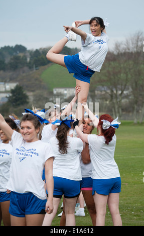 "Tarannau' de fútbol americano universitario de Aberystwyth porristas mostrar equipo realizar rutina acrobática Gales UK Foto de stock