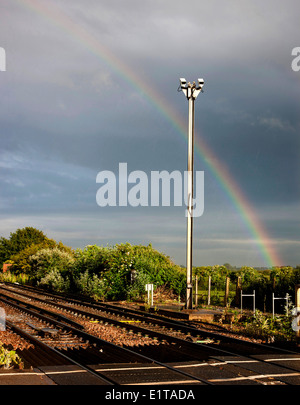 Un arco iris por encima de una línea de ferrocarril Foto de stock
