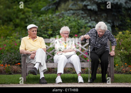 Los ancianos sentados en un banco del parque, Assiniboine Park, Winnipeg, Manitoba, Canadá Foto de stock