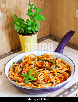 Bucatini Pomodoro (salsa de tomate) con verduras de temporada en una sartén. Pasta Vegetariana.
