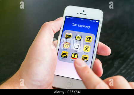 Detalle de la pantalla del iPhone con muchas aplicaciones móviles para reservar taxis Foto de stock