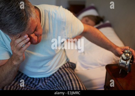 El hombre despierto en la cama sufriendo con insomnio Foto de stock