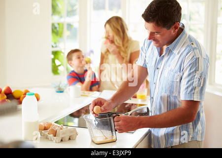 Padre de Familia prepara el desayuno en la cocina Foto de stock