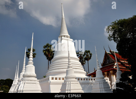 AYUTTHAYA, Tailandia: una fila de pequeños Chedis blancos con espirales anillado blanco rodea la gran campana central Chedi situado Foto de stock