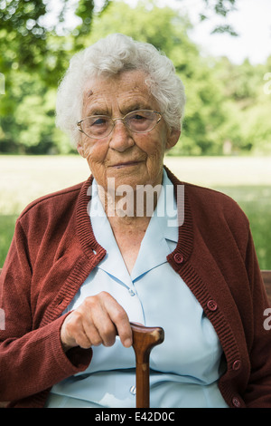 Retrato de mujer mayor, sosteniendo un bastón