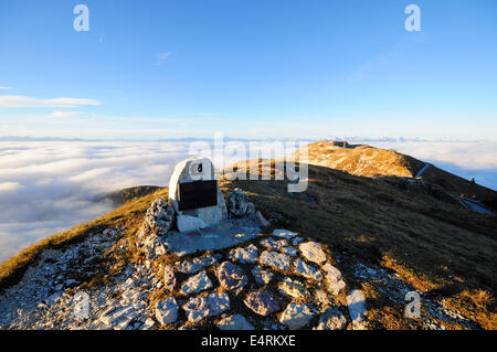 Monumento militar en la cima de una montaña con una luz que emerge de las nubes