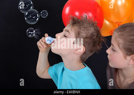 Los niños haciendo pompas de jabón Fotografía de stock - Alamy