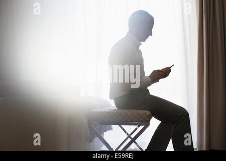 Silueta de hombre utilizando teléfono celular