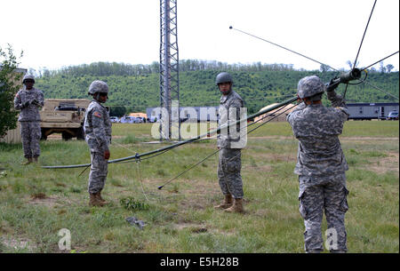 Soldados estadounidenses con la 187ª Compañía de señales, la Guardia Nacional del Ejército de Nueva York, elevar un OE254 antena durante el desempeño basadas en el escenario. Foto de stock